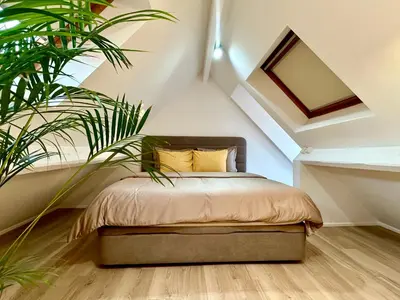 a bedroom with a bed with a plant at Luxury Suites Royal by Rikas Hotels in Antwerp