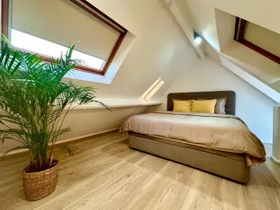 a bedroom with a bed and a potted plant at Luxury Suites Royal by Rikas Hotels in Antwerp