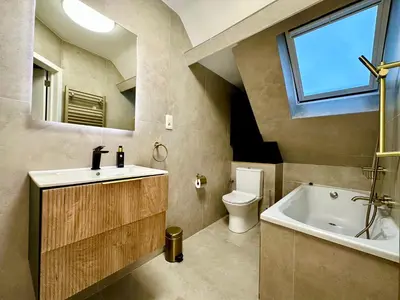 a bathroom with a sink and a tub and a toilet at Luxury Suites Royal by Rikas Hotels in Antwerp