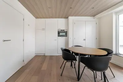 a dining room with a wooden table and black chairs at Luxury apartment x big terrace in Sint-Niklaas