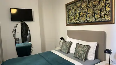 a bedroom with a bed with a mirror and a tv at Happy Home in Brussels
