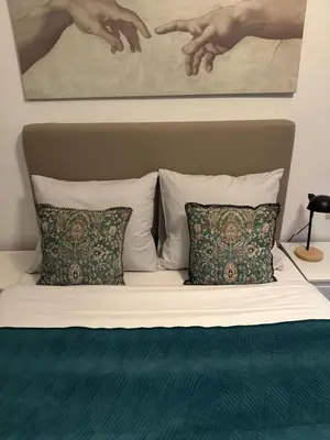 a bed with two pillows and a painting on the wall at Happy Home in Brussels