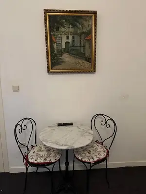 a table with two chairs and a picture on a wall at Happy Home in Brussels