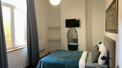 a bedroom with a bed and a mirror and a window at Happy Home in Brussels