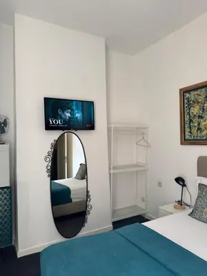 a bedroom with a mirror and a bed and a tv at Happy Home in Brussels