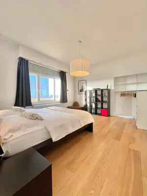 a bedroom with a large bed and a large window at Lovely loft in Panoramic View! in Brussels