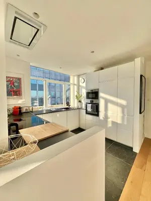 a kitchen with white cabinets and a counter top at Lovely loft in Panoramic View! in Brussels