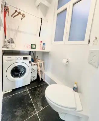 a bathroom with a toilet and a washing machine at Lovely loft in Panoramic View! in Brussels