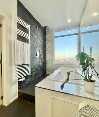 a bathroom with a white sink and a large window at Lovely loft in Panoramic View! in Brussels