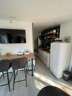 a kitchen with a table and a white refrigerator at Nomad Laryssiou on camping GT Keiheuvel parcel 371 in Balen