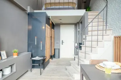 a staircase in a living room with a dining room table at Serene Studio Oasis with Balcony in Ghent in Ghent