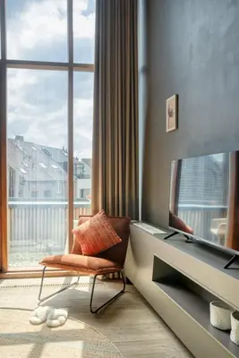 a living room with a chair and a large window at Serene Studio Oasis with Balcony in Ghent in Ghent