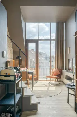 a living room with a large window and a couch at Serene Studio Oasis with Balcony in Ghent in Ghent