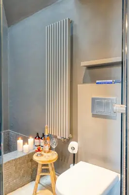 a bathroom with a table and a toilet and candles at Serene Studio Oasis with Balcony in Ghent in Ghent