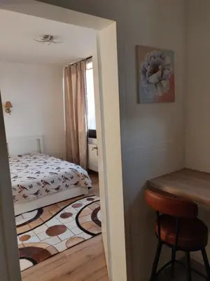 a small bedroom with a bed and a table at Lisbethe in Brussels