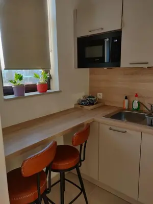 a kitchen with two bar stools and a sink at Lisbethe in Brussels