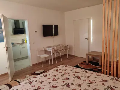 a bedroom with a table and a television on the wall at Lisbethe in Brussels