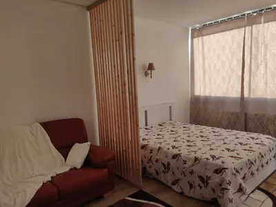 a bedroom with a bed and a couch and a window at Lisbethe in Brussels