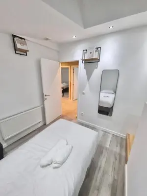a bedroom with a white bed and a chair at Plantin 4 in Brussels