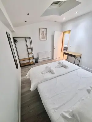 a white bedroom with two white beds and a desk at Plantin 4 in Brussels