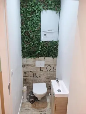 a bathroom with a green wall with a toilet and a sink at Plantin 4 in Brussels