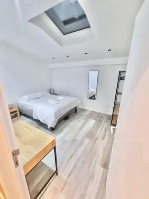 a white bedroom with a bed and a table at Plantin 4 in Brussels