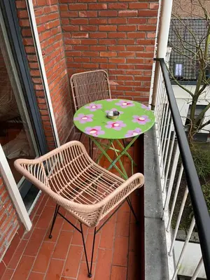a table and two chairs and a table with flowers on a balcony at The Green Gatsby in Antwerp