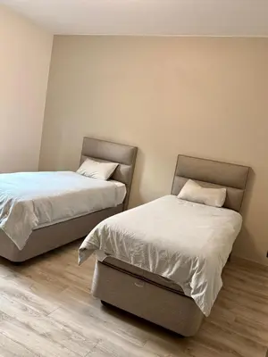 two beds sitting next to each other in a room at l'imperial WIFI & Confort in Brussels