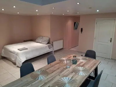 a bedroom with a bed and a wooden table and chairs at House near Forest 125 m² for 6 guests in Brussels