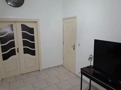 a living room with two doors and a television at House near Forest 125 m² for 6 guests in Brussels