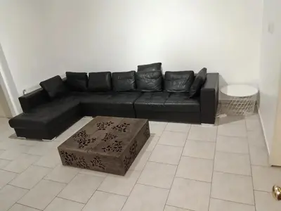 a black leather couch in a living room at House near Forest 125 m² for 6 guests in Brussels