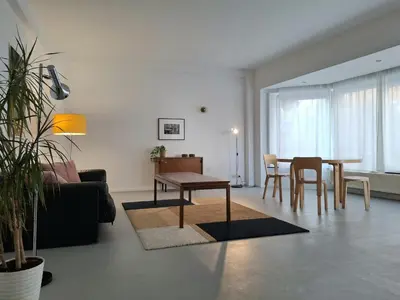 a living room with a couch and a table and chairs at Central in the heart of Brussels in Brussels