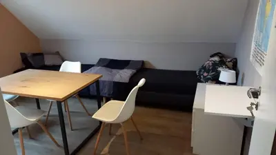 a room with a bed and a table and chairs at Julie's Place in Westerlo