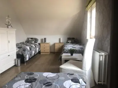 a bedroom with two beds and a table and a chair at Julie's Place in Westerlo
