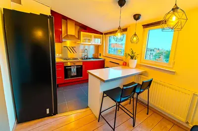 a kitchen with red cabinets and a black refrigerator at Brussels Quiet Oasis in Brussels