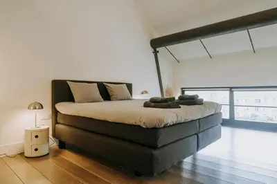 a large bed in a room with a large window at Magnificent loft - 3 bedroom duplex in Brussels