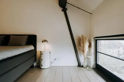 a bedroom with a bed and a large window at Magnificent loft - 3 bedroom duplex in Brussels