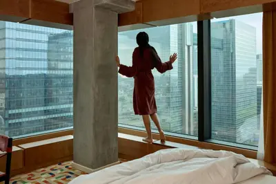 a woman looking out of a window at a city at The Standard, Brussels in Brussels
