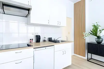 a kitchen with white cabinets and a sink at Studio calme et fonctionnel – idéal séjour pro in Brussels