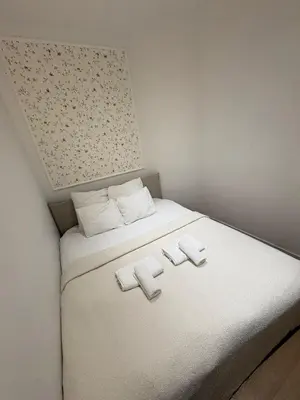 a small room with a white bed with three towels at Charming studio, perfect getaway in Brussels