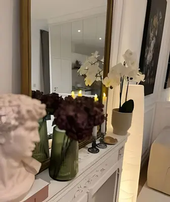 a bathroom with a counter with flowers and a mirror at Charming studio, perfect getaway in Brussels