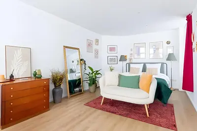 a bedroom with a bed and a chair and a mirror at Studio lumineux, idéal pour séjour pro in Brussels