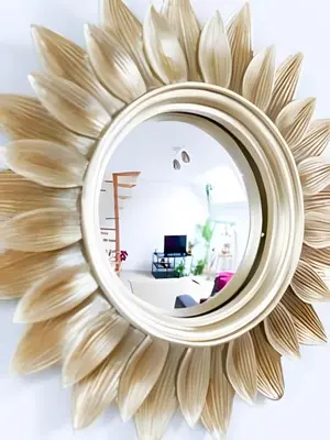 a large wooden sunburst mirror in a living room at Appartement cosy et central – séjour pro in Brussels