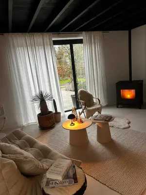 a living room with a couch and a chair and a fireplace at English Bob in Bierbeek