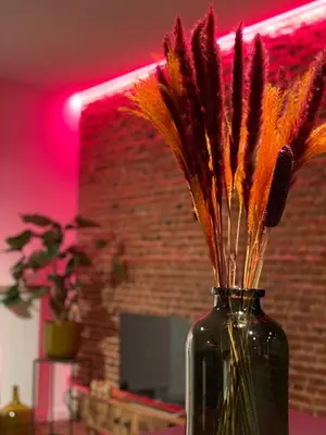 a glass vase with feathers in it on a table at The Green Gatsby II in Antwerp