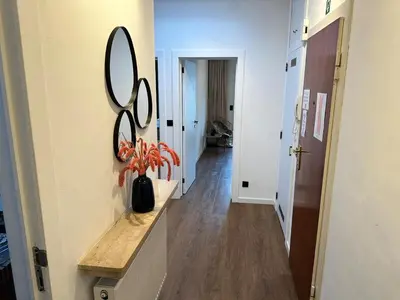 a hallway with a mirror and a vase with flowers at The Green Gatsby II in Antwerp
