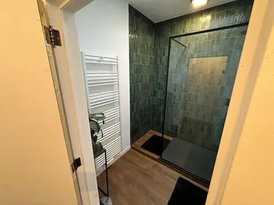 a bathroom with a shower with a glass door at The Green Gatsby II in Antwerp