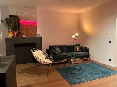 a living room with a couch and a fireplace at The Green Gatsby II in Antwerp