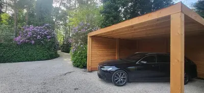 a black car parked under a wooden garage at Stavros in Schoten