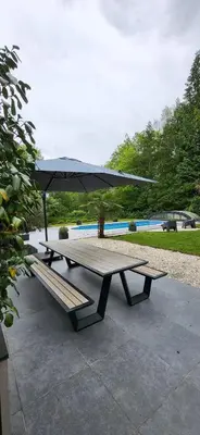 a picnic table with an umbrella and a bench at Stavros in Schoten